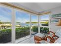 Bright sunroom offers tranquil waterfront views from the rattan seating area at 600 Sutton Pl # 104, Longboat Key, FL 34228