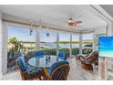 Bright sunroom with dining and lounge area overlooking waterfront and boat docks at 600 Sutton Pl # 104, Longboat Key, FL 34228