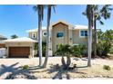 Charming home featuring an oversized garage, lush landscaping, and beautiful stonework at 606 Crestwood Ln, Holmes Beach, FL 34217