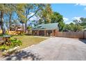 Charming log cabin showing the side of the home with fenced in yard and a long driveway at 6811 6Th W St, Bradenton, FL 34207