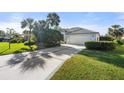 Beautiful single-story home featuring a well-manicured lawn and a spacious driveway leading to a two-car garage at 826 Oak Briar Ln, Osprey, FL 34229