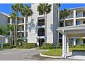 Condo exterior features covered parking, well-manicured landscaping, and several palm trees on a sunny day at 910 Tidewater Shores Loop # 107, Bradenton, FL 34208