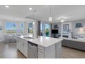 Open-concept kitchen with quartz countertops, and stainless steel appliances, with view of waterfront at 910 Tidewater Shores Loop # 107, Bradenton, FL 34208