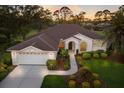 Aerial view of a home showcasing lush landscaping, a tiled roof, and an attached two-car garage at 9408 Glen Abbey Ln, Sarasota, FL 34238