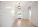 Bright entryway with shiplap accent wall, decorative lighting, and view of the front door at 11165 Balfour St, Venice, FL 34293