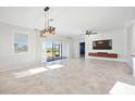 Open living room with large windows, tile flooring, modern lighting, and accent wall at 11165 Balfour St, Venice, FL 34293