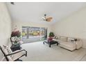Bright living room with neutral tones, ceiling fan, and access to the screened-in lanai at 1511 Waterford Dr, Venice, FL 34292
