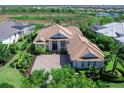 An aerial view of a sprawling one-story home surrounded by lush greenery in a serene community at 16407 Daysailor Trl, Lakewood Ranch, FL 34202