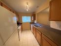 Kitchen with white refrigerator and wooden cabinets at 1721 Parakeet Way # 700, Sarasota, FL 34232