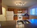 Traditional kitchen with stainless steel sink, white appliances, and wooden cabinets at 1721 Parakeet Way # 700, Sarasota, FL 34232