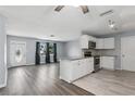 Open-concept living space with modern gray wood flooring and bright kitchen at 2039 Kai Dr, Sarasota, FL 34231