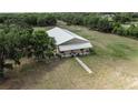 Aerial view of a charming barndominium with a metal roof and well-maintained landscaping at 28120 63Rd E Ave, Myakka City, FL 34251