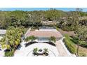 An aerial view displays the property, pool, and attractive landscaping against a backdrop of mature trees at 3304 7Th Street W Ct, Palmetto, FL 34221