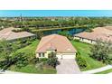 Beautiful home aerial view overlooking lush landscaping, a serene pond, and other similar properties at 428 Grand Preserve Cv, Bradenton, FL 34212