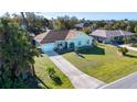 An aerial view of a single story home with a nice lawn, driveway, palm trees and a view of neighborhood homes at 4360 Flamingo Blvd, Port Charlotte, FL 33948