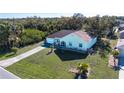 An aerial view of a single story home, landscaped yard, driveway, and surrounding neighborhood at 4360 Flamingo Blvd, Port Charlotte, FL 33948