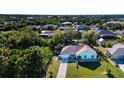 An aerial view of a single story home, landscaped yard, driveway, and surrounding neighborhood at 4360 Flamingo Blvd, Port Charlotte, FL 33948