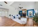 Cozy living room featuring a stone fireplace, wood floors, neutral furnishings, and abundant natural light at 4406 17Th W St, Palmetto, FL 34221