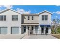 Charming townhome with gray facade, paired garage, and a welcoming entrance with black metal fence at 4656 Pleasant Ave, Palm Harbor, FL 34683