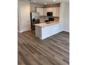 Modern kitchen featuring white cabinets, stainless steel appliances, and a spacious island with quartz countertop at 4656 Pleasant Ave, Palm Harbor, FL 34683