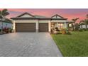 Beautiful single-story home with a well manicured lawn, paver driveway, and a two-car garage at 4820 Coastal Days Ln, Bradenton, FL 34211