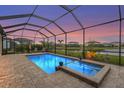 A private screened-in pool and jacuzzi are surrounded by lush landscaping, and a lake view at 4820 Coastal Days Ln, Bradenton, FL 34211
