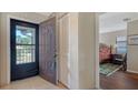 Entryway features a storm door, coat closet, neutral tile, and a view of the bedroom at 5630 Golf Pointe Dr # 205, Sarasota, FL 34243
