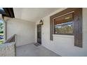 Front porch features a small outdoor light fixture, a welcome mat, and a window with blinds at 5630 Golf Pointe Dr # 205, Sarasota, FL 34243