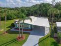 Inviting home with a covered carport, mature landscaping, and beautiful green lawn at 5910 Majestic Way, Palmetto, FL 34221