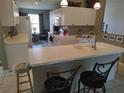 Bright, open kitchen featuring a breakfast bar, white cabinetry, and views into the living and dining areas at 6821 Fairview Ter # 6821, Bradenton, FL 34203