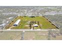 Expansive aerial view showcases the property's vast land, outbuildings, and serene pond with a marked property line at 7150 Richardson Rd, Sarasota, FL 34240