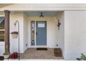 Inviting front porch features a blue door, a hanging plant, and a decorative accent, enhancing curb appeal at 7150 Richardson Rd, Sarasota, FL 34240