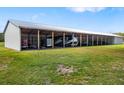 Large metal outbuilding provides ample covered parking and storage on grassy lot, perfect for equipment or vehicles at 7150 Richardson Rd, Sarasota, FL 34240