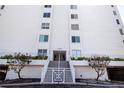 Front entrance of building with stairway, sidewalk, greenery, and lamp post at 1080 Peppertree W Ln # 602, Sarasota, FL 34242
