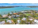 Beautiful aerial view of canal-front houses, lush landscaping, and turquoise waters with a city skyline at 111 Faubel St, Sarasota, FL 34242