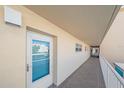 Exterior hallway entrance door featuring glass panel, the number 203, and a view of the complex through the glass at 1250 N Portofino Dr # 203, Sarasota, FL 34242
