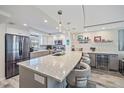 Open kitchen featuring an oversized island with pendant lighting, stainless appliances, and built-in wine storage at 1250 N Portofino Dr # 203, Sarasota, FL 34242