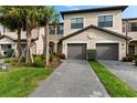 Inviting two-story home with a gray brick driveway, lush landscaping, and a two car garage at 15225 Lyla Ter, Bradenton, FL 34211