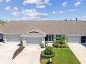 Aerial view of a well maintained villa featuring manicured landscaping, attached garages, and a double driveway at 2908 Fiddlers Bnd, Palmetto, FL 34221