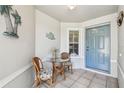 A cozy front porch with a table, chairs, and a charming blue door that welcomes guests at 2908 Fiddlers Bnd, Palmetto, FL 34221