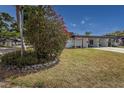 Well-manicured front yard showcasing lush landscaping and a view of the inviting home with covered parking at 3908 Panola Ln # 193, Sarasota, FL 34232