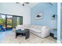 Comfortable living room featuring a large sofa, round coffee table, and a view of the screened-in patio at 3910 Cape Haze Dr, Rotonda West, FL 33947