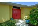 Inviting entrance with vibrant red double doors, lush greenery, and a well-maintained walkway at 4662 Long Lake Dr, Sarasota, FL 34233