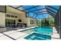 Gorgeous screened-in pool and patio area featuring a hot tub and outdoor kitchen, perfect for entertaining guests at 4706 Balboa Park Loop, Bradenton, FL 34211