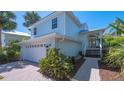 Charming two-story home featuring an attached garage, lush landscaping, and covered porch at 4922 Commonwealth Dr, Sarasota, FL 34242