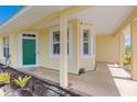 Inviting front porch featuring a green front door and stone flooring at 5319 Levi Ln, Sarasota, FL 34233