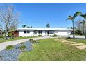 Beautiful one-story home with lush front yard, walkway and driveway, palm trees, and modern architectural style at 537 Gunwale Ln, Longboat Key, FL 34228