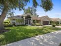 Charming single-story home with manicured lawn, lush landscaping, and a spacious two-car garage at 555 Park Estates Sq, Venice, FL 34293