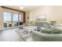 Bright and airy living room with a balcony, light wood floors and tasteful coastal decor at 615 Riviera Dunes Way # 208, Palmetto, FL 34221