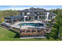 Backyard featuring an outdoor kitchen, an open patio, and a luxurious pool surrounded by an elegant patio at 6178 9Th Avenue Ne Cir, Bradenton, FL 34212